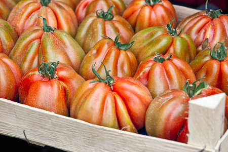 Fresh Ribbed Heirloom Tomatoes in Wooden Crateの写真素材