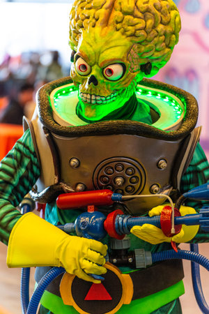 Alien cosplay with toy weapon at comic and video game fair in Genoa