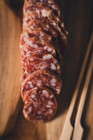 Italian Salami Slices on Wooden Board Close-Upの写真素材