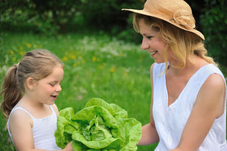 Young mother and daughter with lettuceの写真素材