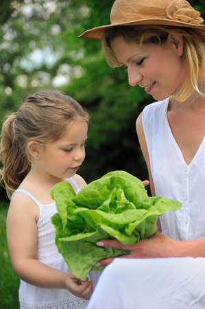 Young mother and daughter with lettuceの写真素材