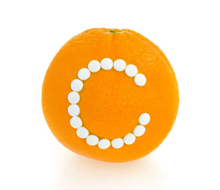 Orange with vitamin c pills over white background - conceptの写真素材