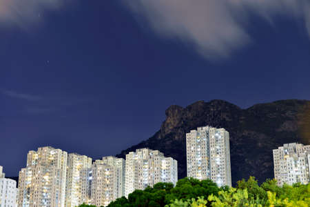 Kowloon residential building with lion rock mountainの写真素材