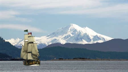 Mount Baker looms over the tall ship Lady Washington off Sidney, on Vancouver Island, British Columbia, Canadaのeditorial素材