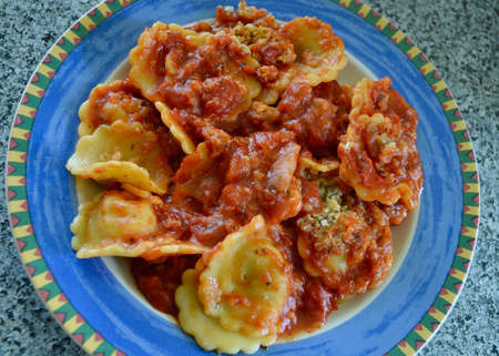 Spinach and ricotta ravioli on a colorful plateの写真素材