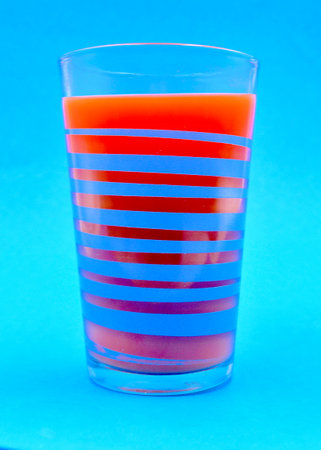 Glass of carrot juice with apple juice and a little ginger on a blue background, close-up.の写真素材