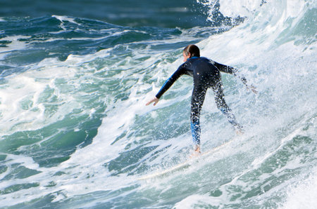 Surfer in action on the ocean waves on a sunny day.