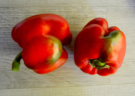 Red bell peppers on a wooden background. Top view. Flat lay.