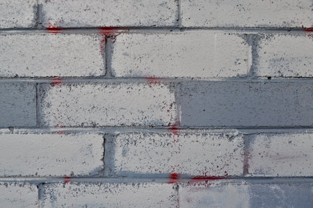 brick wall with red and white paint, closeup of photo