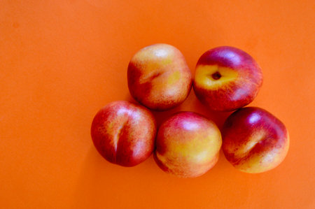 Ripe nectarines on orange background. Top view, copy spaceの写真素材