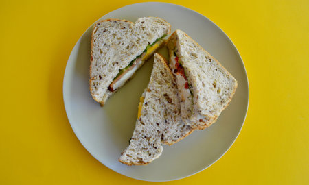 Sandwiches on a white plate on a yellow background. Top view.の写真素材