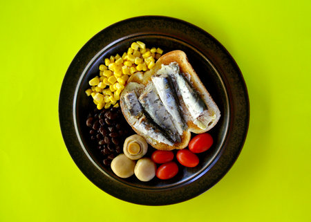 Sandwich with sardines, tomatoes and corn on a green backgroundの写真素材