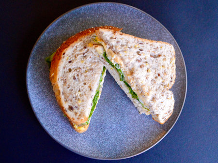 An egg and lettuce sandwich made with multi grain bread.