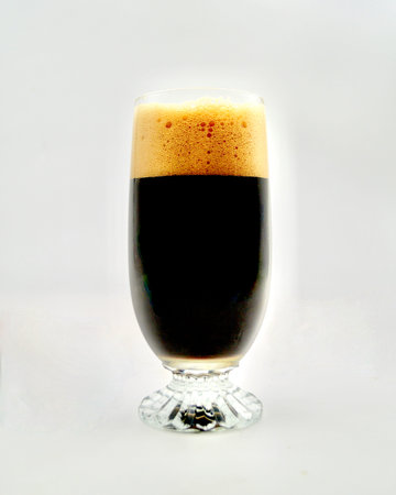 A glass of dark beer on a white background. Isolated.