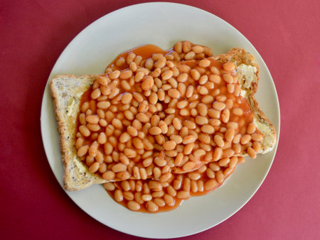 Baked beans in tomato sauce and bread on plate, top viewの写真素材