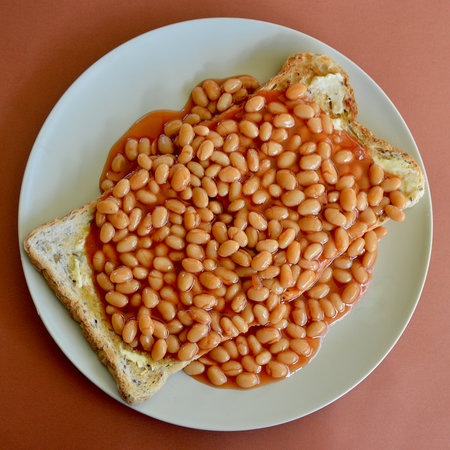Baked beans in tomato sauce with toasted bread on a plateの写真素材