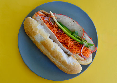 A Vietnamese style pork roll with vegetables on a blue plate on a yellow background.の写真素材
