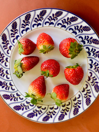 Strawberries on a white plate with a blue and white patternの写真素材