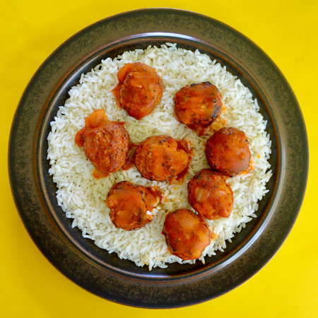 Rice with meatballs on a yellow background. Top view.