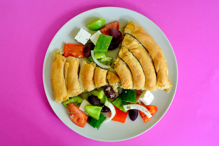 Puff pastry with olives and tomato on pink backgroundの写真素材