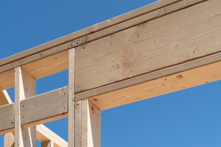 New home construction focusing on the corner elements of a rough door opening, featuring the corner of a header, king stud, trimmers, and double top plate.の写真素材