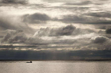 Fishing boat against a dramatic sky over the North Sea in Scotland.の写真素材