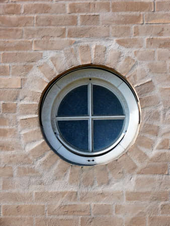 portrait of round window and a modern yellow brick wall の写真素材