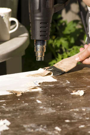 portrait of renovation; removing old paint using scraper and heat gunの写真素材