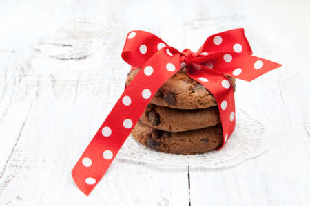 Festive wrapped chocolate homemade cookies on white wooden backgroundの写真素材