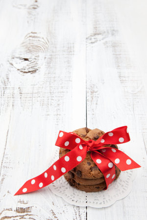 Festive wrapped chocolate homemade cookies on white wooden background