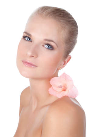 Closeup face of fashion model with pink gladiolus on her shoulder. Looking at camera.  Isolated on white background.の写真素材