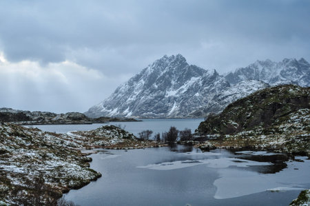 Frosty view on a norwegian fjord after snow showers with the sun breaking through the clouds 