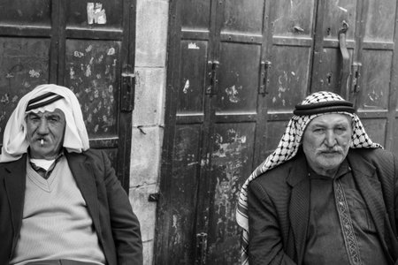 Two palestinian men are sitting having a chat an zigarettes in the old part of the town og hebron...