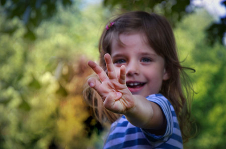 The happy little girl is playing in the garden.の写真素材
