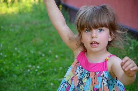 A little girl joking in the garden.の写真素材