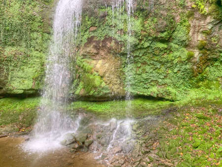 Ein Wasserfall stÃ¼rzt eine Felswand herabの写真素材