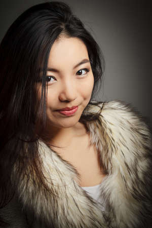Attractive asian girl in her twenties isolated on a plein background shot in a studioの写真素材