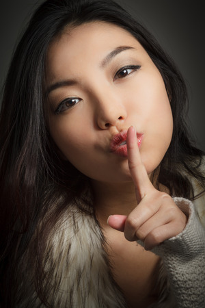 Attractive asian girl in her twenties isolated on a plein background shot in a studioの写真素材