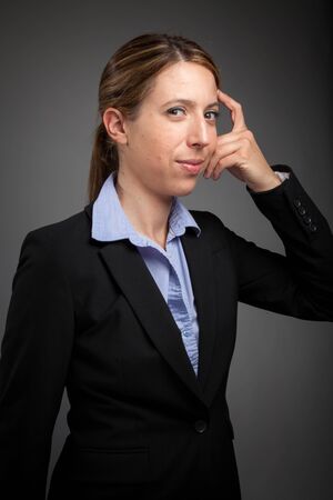 Attractive caucasion business woman in her 30s shot in studio isolated on a white background in her 30s shot in studio isolated on a grey backgroundの写真素材