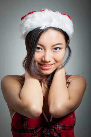 Attractive sexy santa claus asian girl in her 20s isolated on a grey  backgroundの写真素材