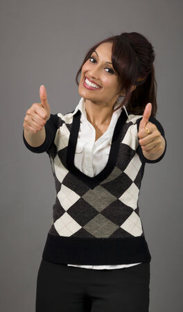 Indian businesswoman showing thumbs up from both hands isolated on colored backgroundの写真素材