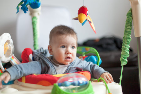 Baby boy playing in a baby carriage
