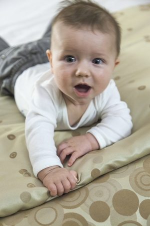 Close-up of a baby boy playing on a bedの写真素材