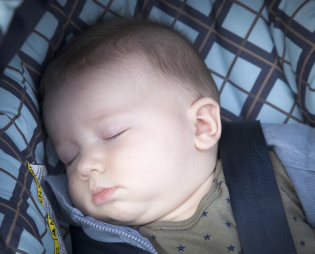 Baby boy sleeping in a baby carriageの写真素材