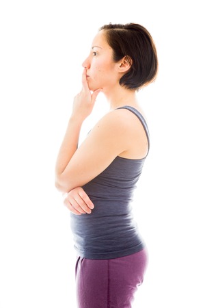 Side profile of a young woman thinking with hand on chinの写真素材