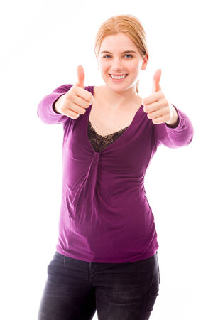 Young woman showing thumbs up towards camera with both handsの写真素材