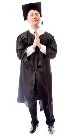 Senior male graduate holding hands together and prayingの写真素材