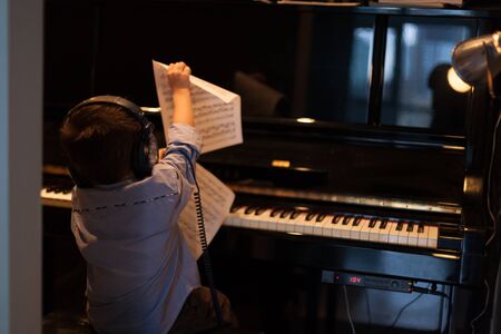 Rear view of a little boy learning pianoの写真素材