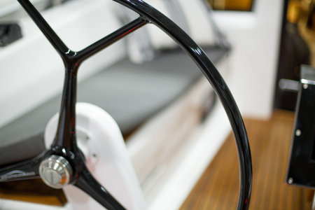 Black steering wheel of a boat