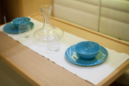 Empty wine decanter with glasses on a dining table in a yachtの写真素材